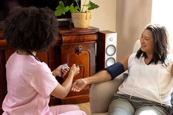 a healthcare professional taking blood pressure of a woman in a cozy home setting emphasizing health and wellness for three key measurements