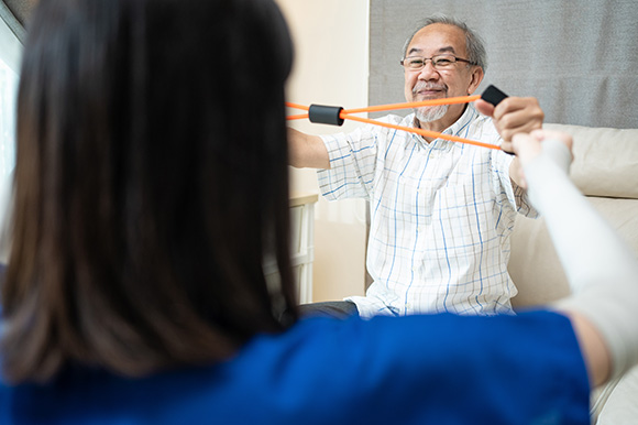 senior man exercising with resistance bands during physical therapy session focused on rehabilitation and strength improvement for seniors 10 effective exercises