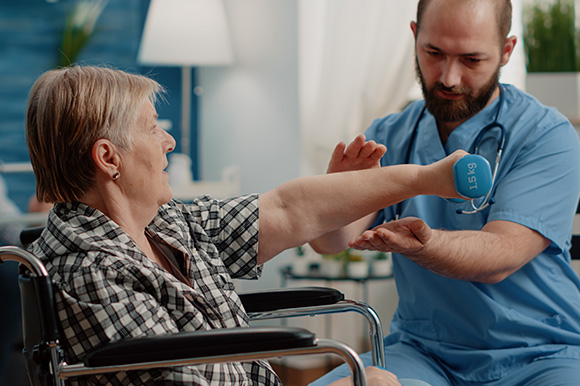 elderly woman in wheelchair receiving care from healthcare professional during medical assessment with emphasis on arm strength 6 steps to recovery
