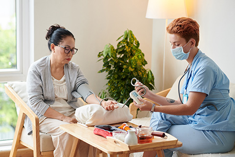 healthcare professional measuring blood pressure of elderly patient in a cozy home setting with medical equipment and tools for health monitoring