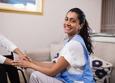 smiling healthcare worker assisting patient in home care environment providing compassionate support and comfort