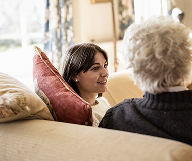 young woman talking with older adult on a sofa in a cozy setting sharing moments together five ways to connect