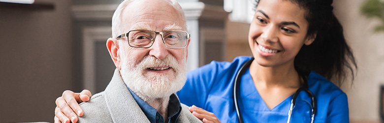smiling elderly man with glasses and caregiver in blue scrubs showing compassion and friendship in healthcare setting 3 ways to support seniors