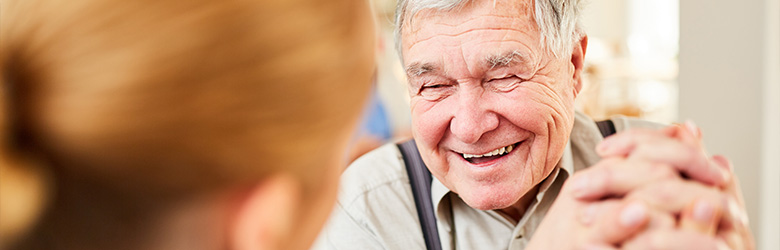 smiling elderly man enjoying conversation with caregiver in bright setting sharing moments of joy and connection