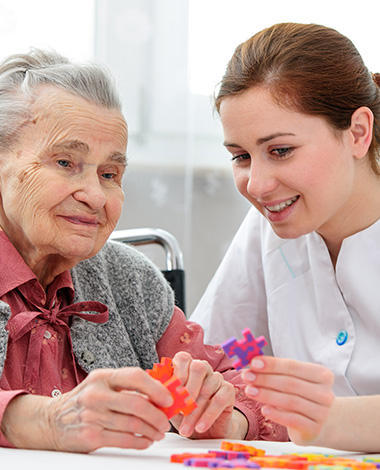elderly woman and caregiver working together on colorful puzzle pieces promoting cognitive engagement and social interaction 3 activities