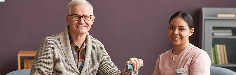 smiling elderly man with caregiver engaging in conversation in a supportive environment promoting health and wellness