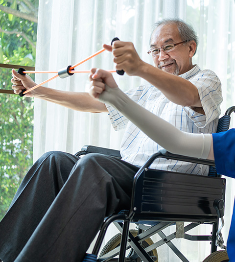 elderly man exercising with resistance bands while sitting in wheelchair during rehabilitation session 5 exercises for strength